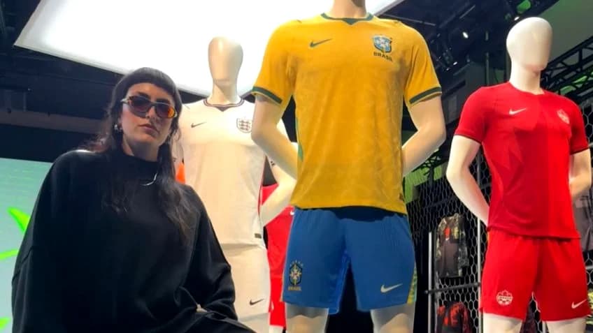 A design Rachel Denti ao lado do uniforme da seleção brasileira para a Copa do Mundo de 2026.
