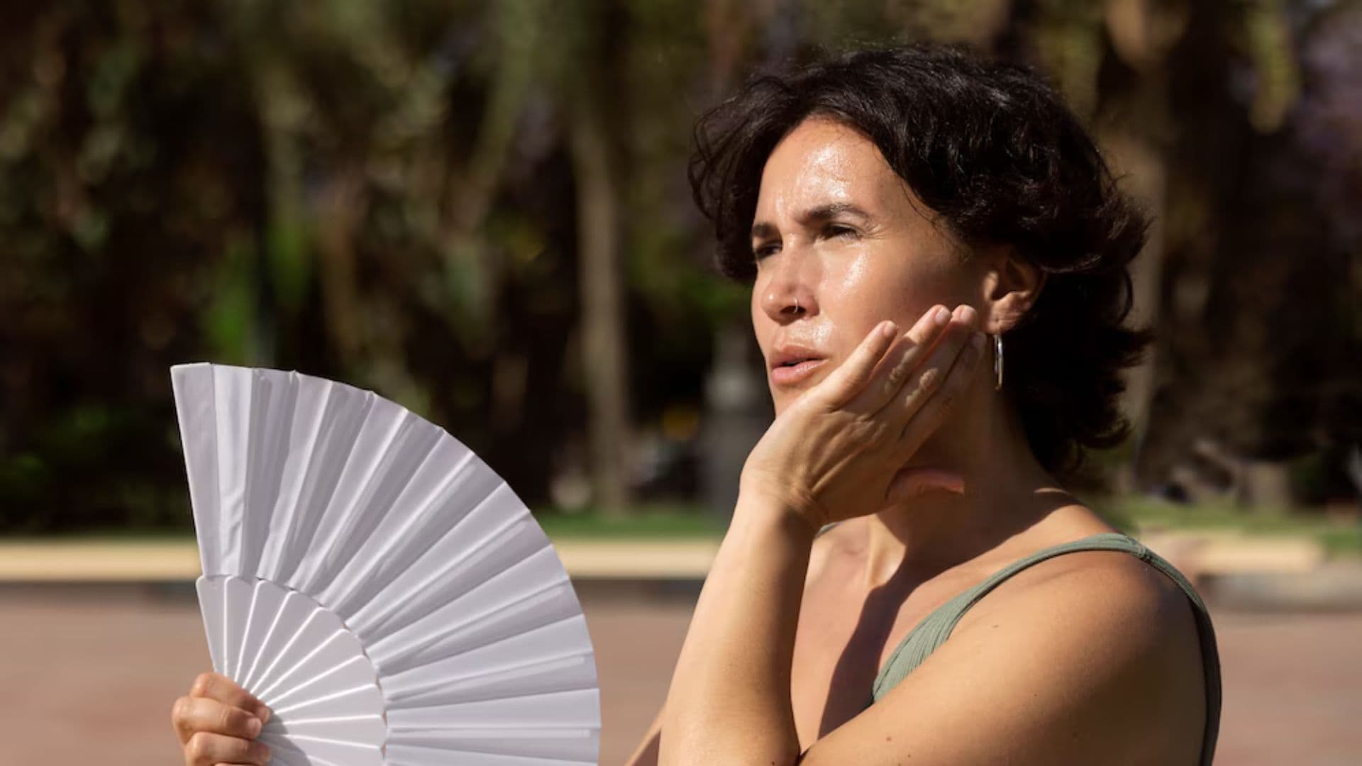 Mulher se abana em um dia de sol