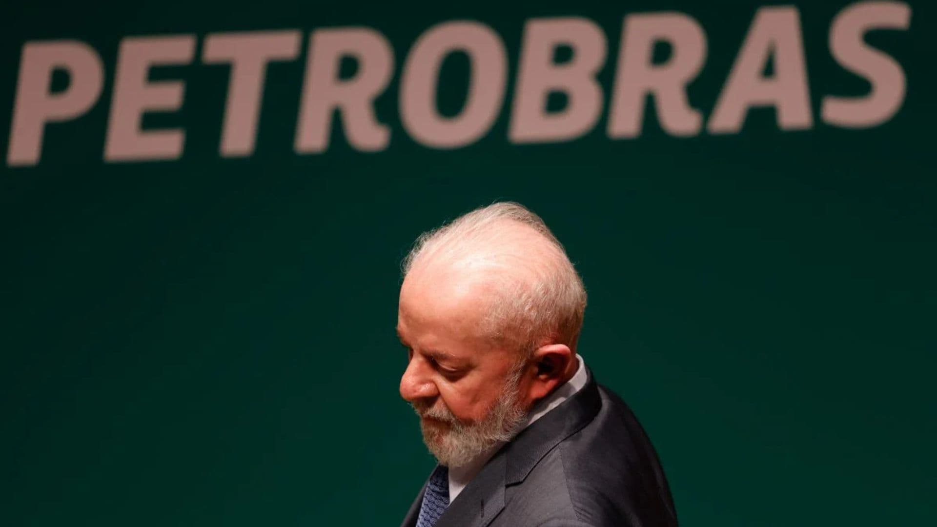 Lula em frente a um Banner da Petrobras.