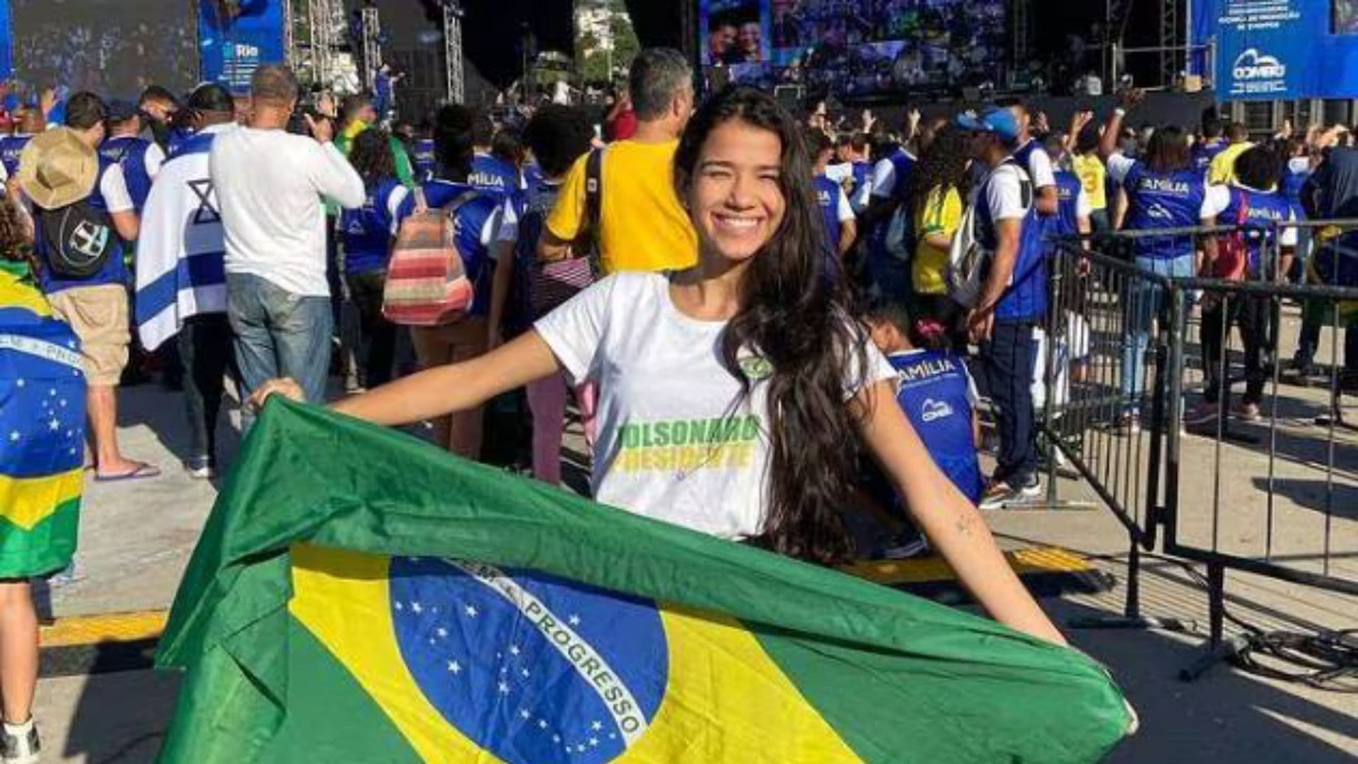 Júlia Castro segurando bandeira brasileira em um evento com simpatizantes de Bolsonaro.