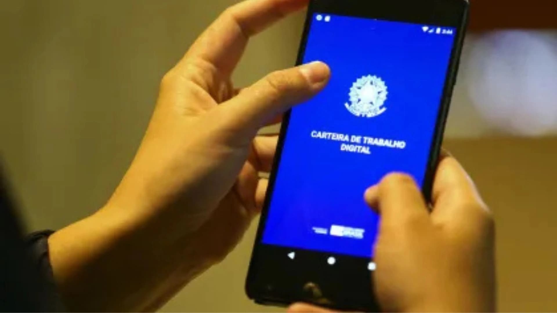 Pessoa segurando uma carteira de trabalho digital.