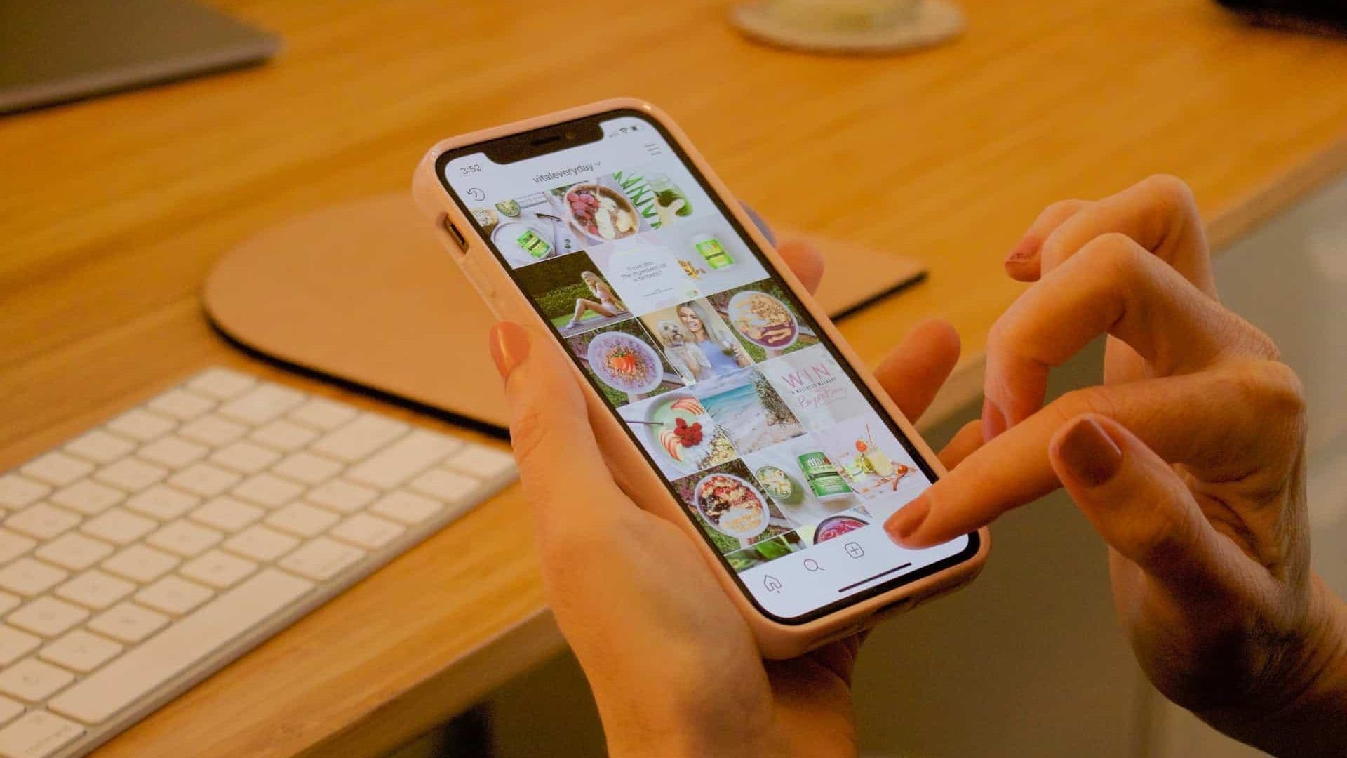 Mulher mexendo no celular e usando o Instagram, provavelmente acessando o Instagram.
