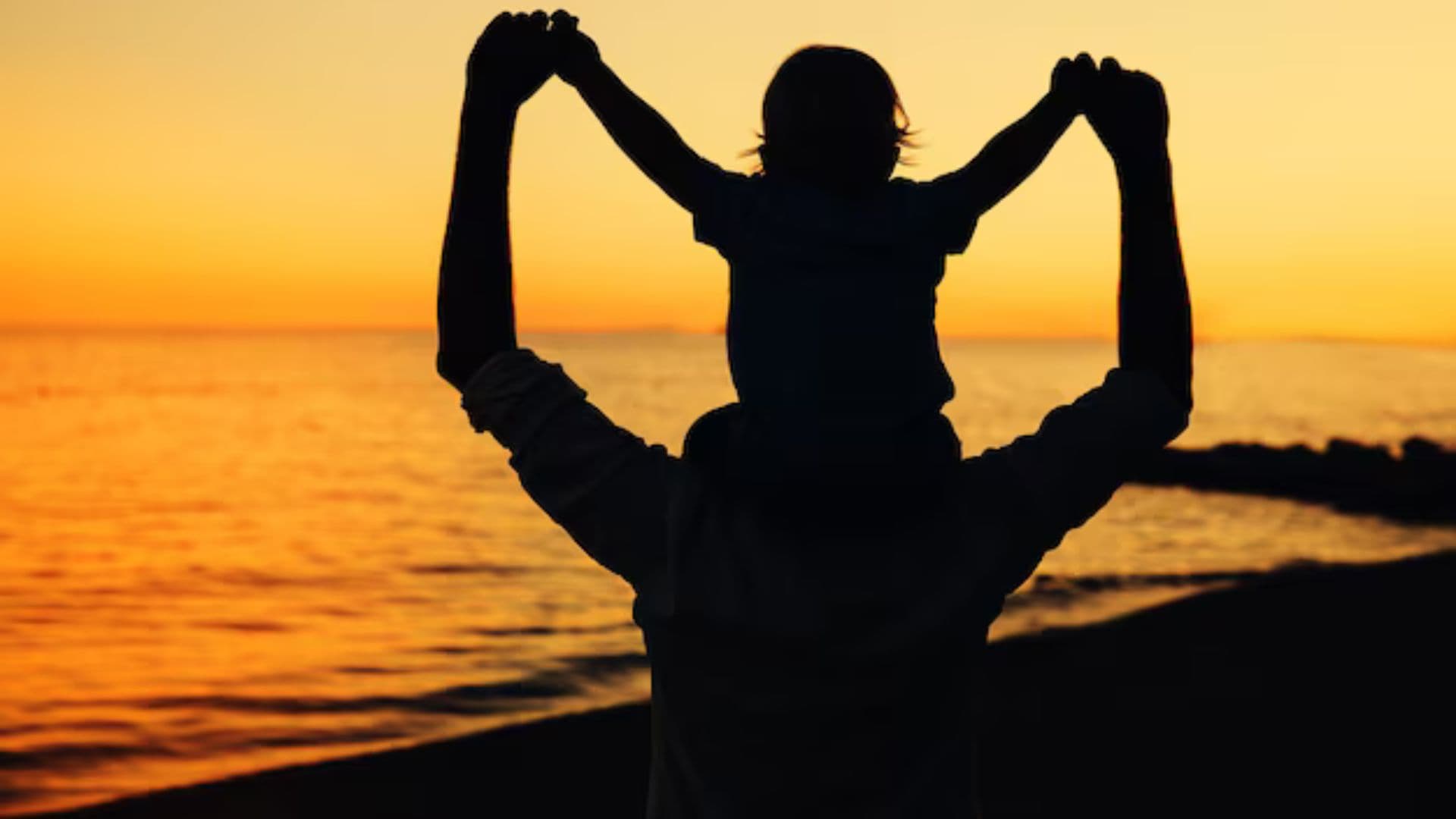 Pai segurando filho nas costas.