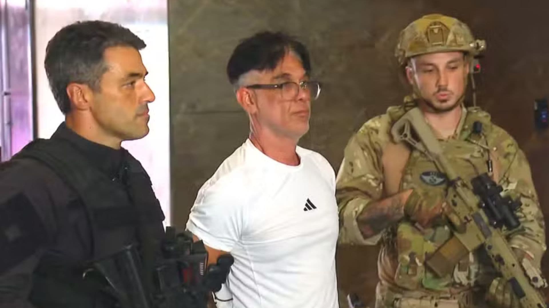 Adilson Oliveira Coutinho Filho, conhecido como Adilsinho, é escoltado por agentes da força integrada de combate ao crime organizado após ser preso em Cabo Frio, na Região dos Lagos do Rio de Janeiro.